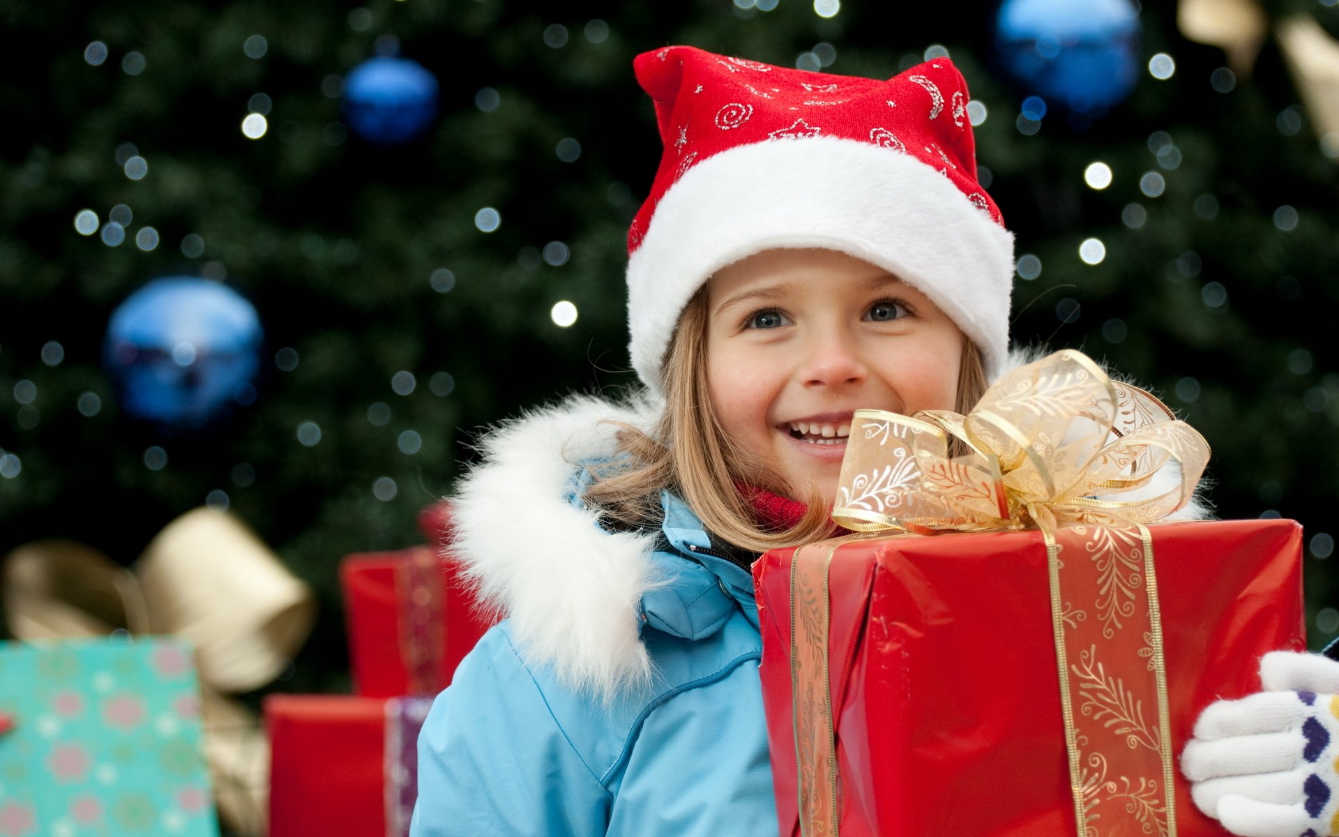 neujahr urlaub kinder mädchen geschenk rot box gold band bogen blau jacke mütze handschuhe lächeln