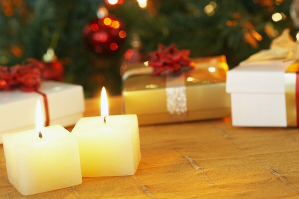 Petites bougies brûlantes dans les cadeaux sous l arbre de Noël