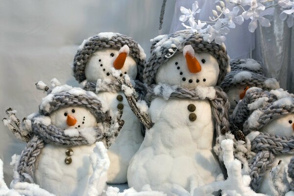 Muñecos de nieve de algodón en gorros y bufandas de punto