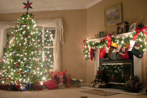 Decorated Christmas tree near the fireplace with gifts