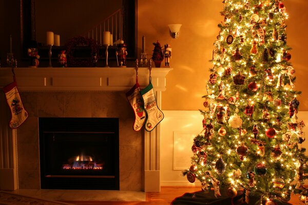 A fire in the fireplace and a lit Christmas tree