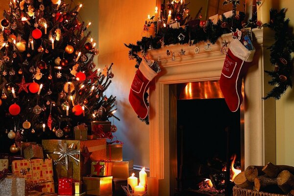 New Year decoration of the fireplace with boots and spruce with gifts