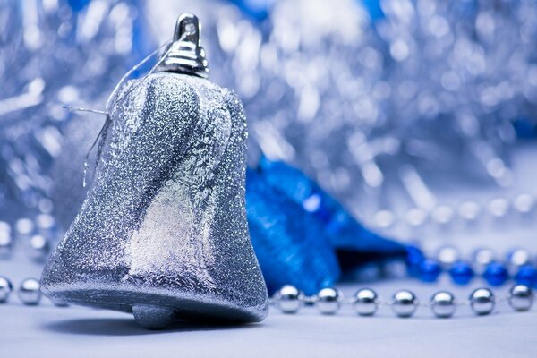 Christmas tree toy in the form of a bell on the background of garlands