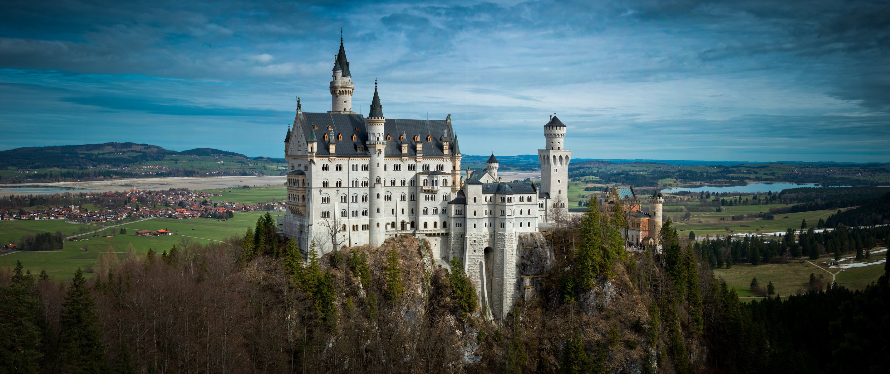 zamek neuschwanstein bawaria niemcy zamek neuschwanstein rzeka pola domy drzewa panorama