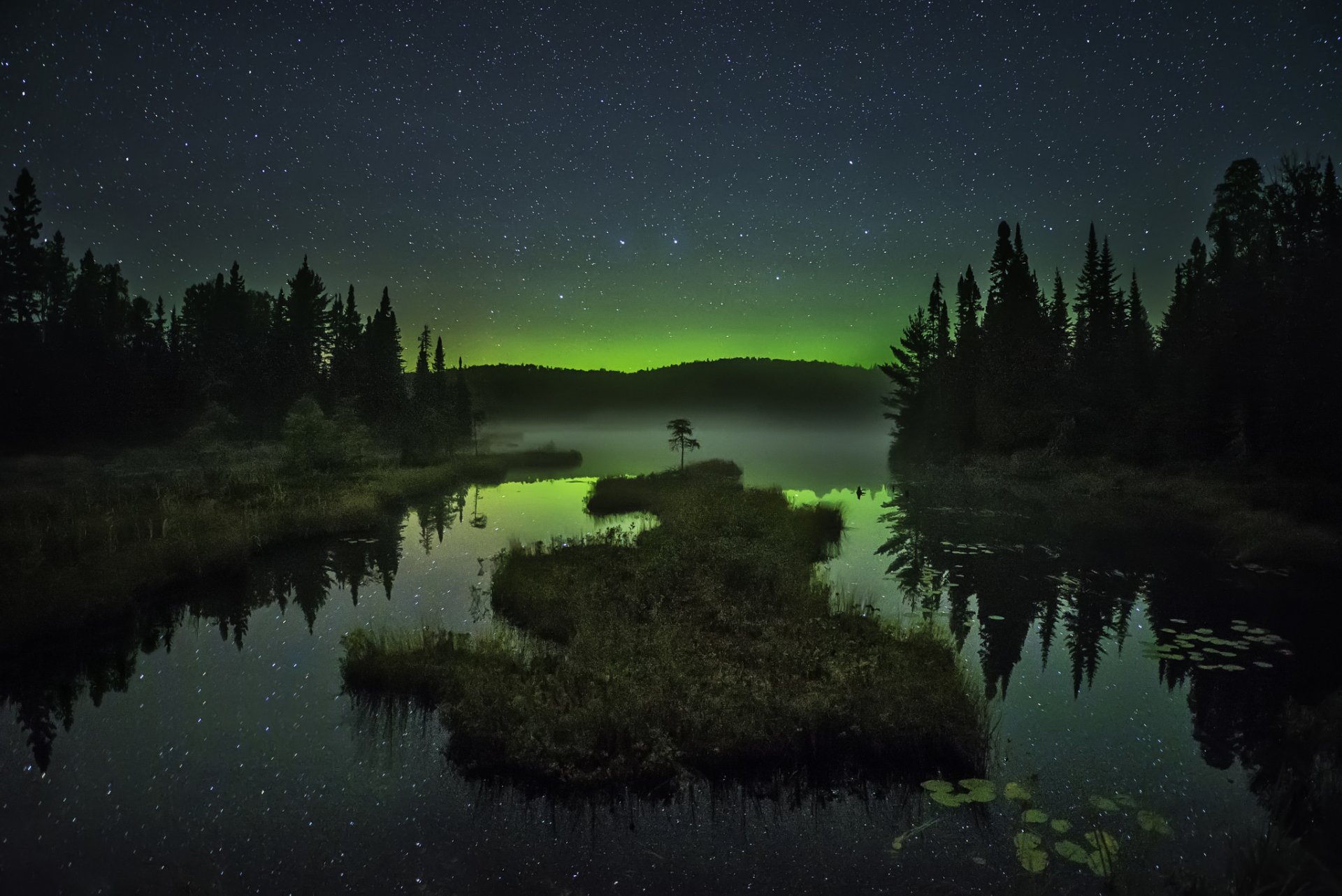 lago islote árboles niebla montañas aurora boreal estrellas cielo noche espejo reflexión