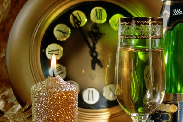 A glass of champagne, a candle, a clock - waiting for the New Year