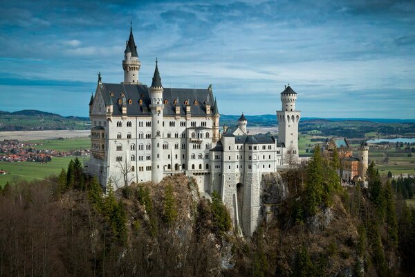 Panorama von Schloss Neuschwanstein. Bewölkter Himmel über dem Feld