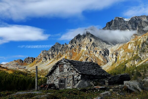 Nuvole sul cielo blu sopra le pendici delle montagne