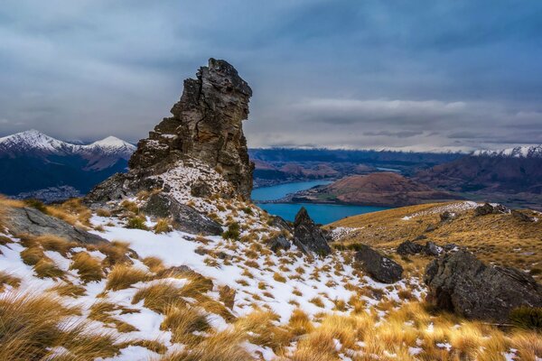 Snowy mountains on the background of a lake and clouds