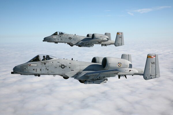 Un par de aviones de ataque a - 10, thunderbolt ii en el cielo sobre las nubes