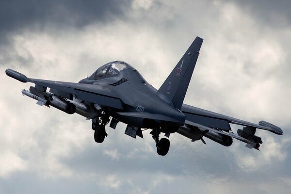 The Yak-130 combat training aircraft flies among white clouds