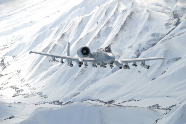 Thunderbolt II attack aircraft flies over snow-covered mountains