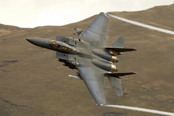 Avión militar f15 vuela sobre el desierto