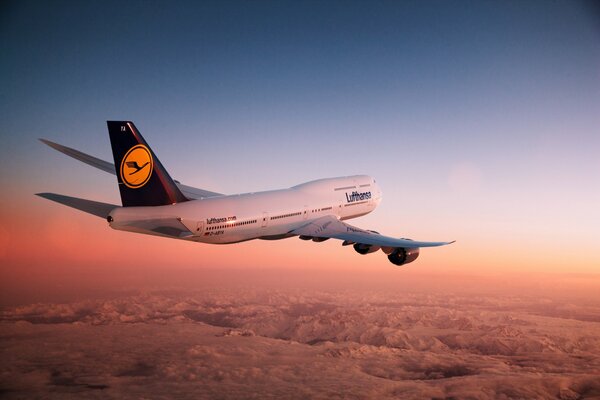 Avion en l air au coucher du soleil sur les montagnes