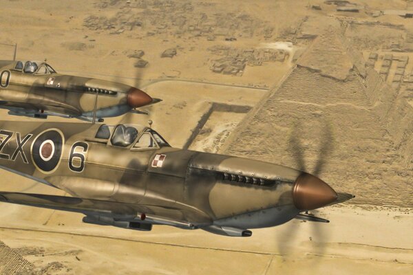 Spitfire Flugzeug in der Wüste vor dem Hintergrund der Pyramiden