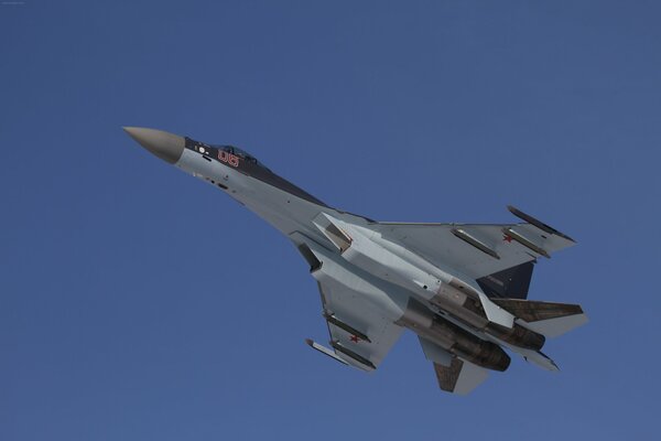 Flugzeug su-35s im Flug vor einem blauen Himmelshintergrund