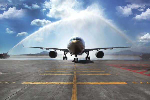 This is how fire trucks meet the arriving passenger airliner airbus a330. First landing at the new airport