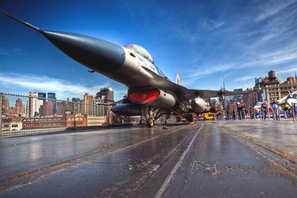 Fighter jet on the runway against the background of the city