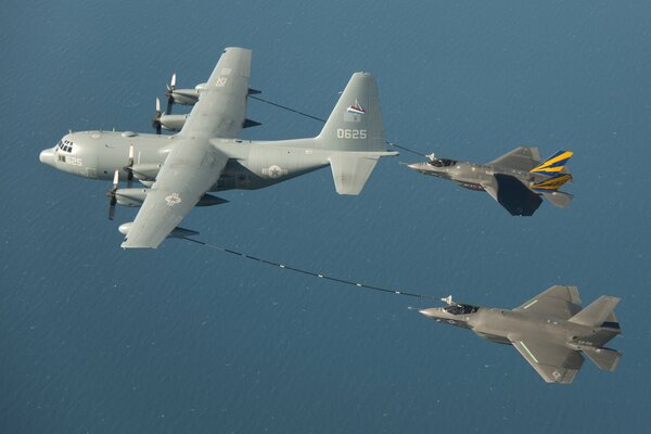 Refueling of two fighters in the sky over the ocean