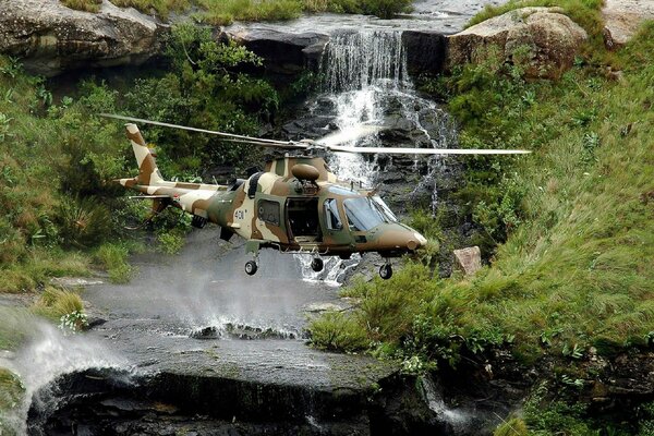 Helicóptero en el fondo de una cascada y un río