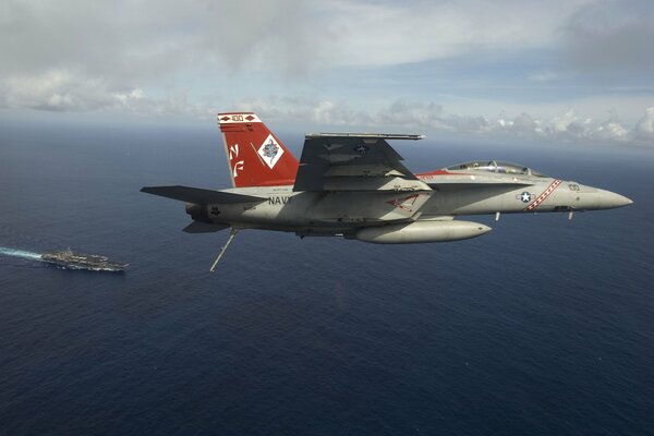 Bombardero de combate vuela sobre un portaaviones