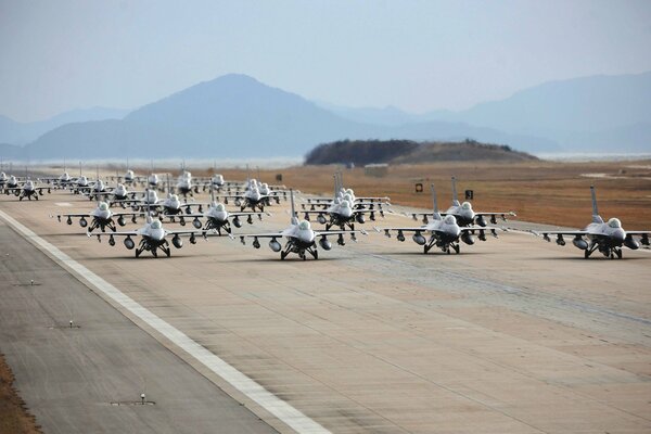 Aviones de combate en la pista de aterrizaje en el fondo de las montañas