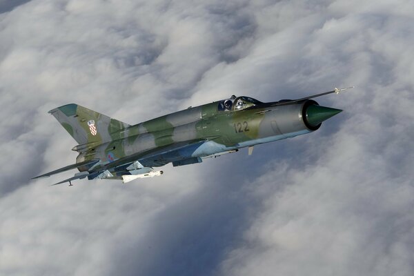 Soviet Mig-21 in the sky with clouds on the background