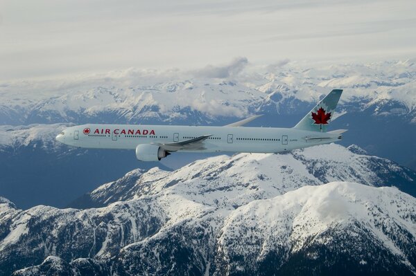 Boing 777 von Air Canada am Himmel über den Bergen