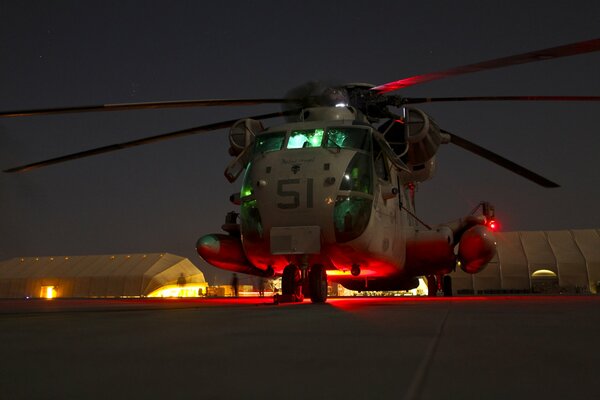 CH-53d se encuentra de noche junto a los cuerpos de Marines