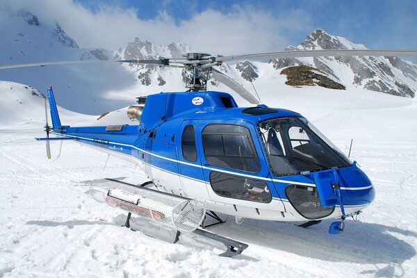 Helicóptero azul en las montañas se prepara para despegar