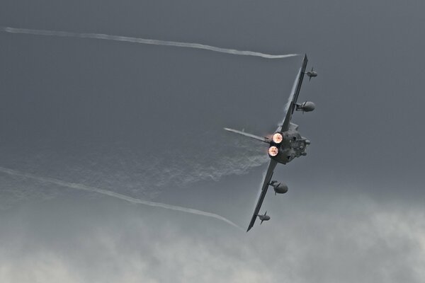 Aereo che fa una curva contro un cielo grigio