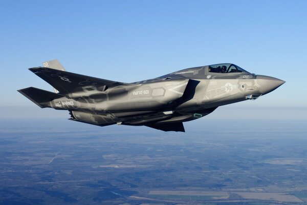 A fighter jet in the sky over the land of the USA