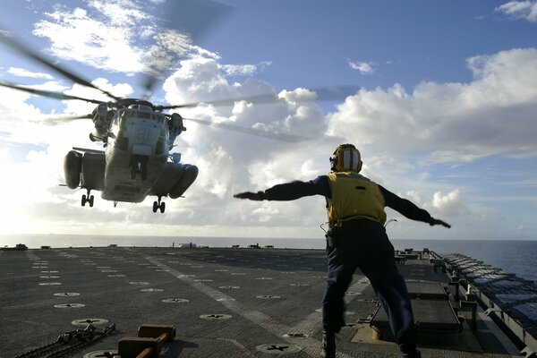 Beautiful helicopter landing on the deck of an aircraft carrier