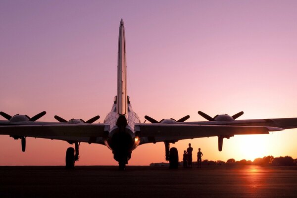 The plane is at the airfield against the sunset