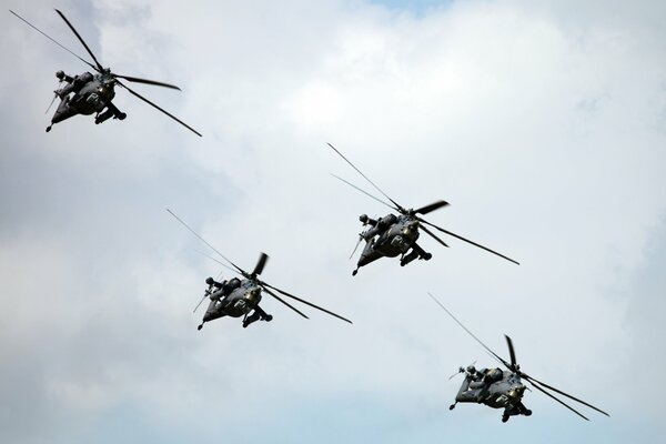 Cuatro helicópteros volando en el cielo