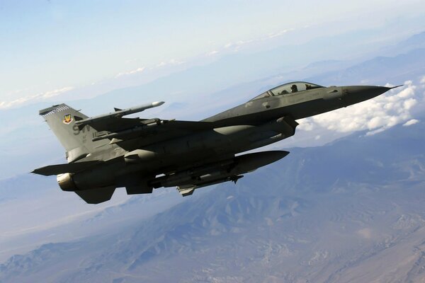 An American F-16 fighter jet flies through the clouds