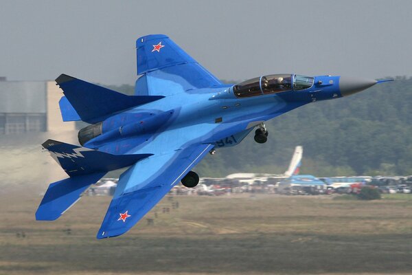 Avión azul MIG vuela hacia el cielo