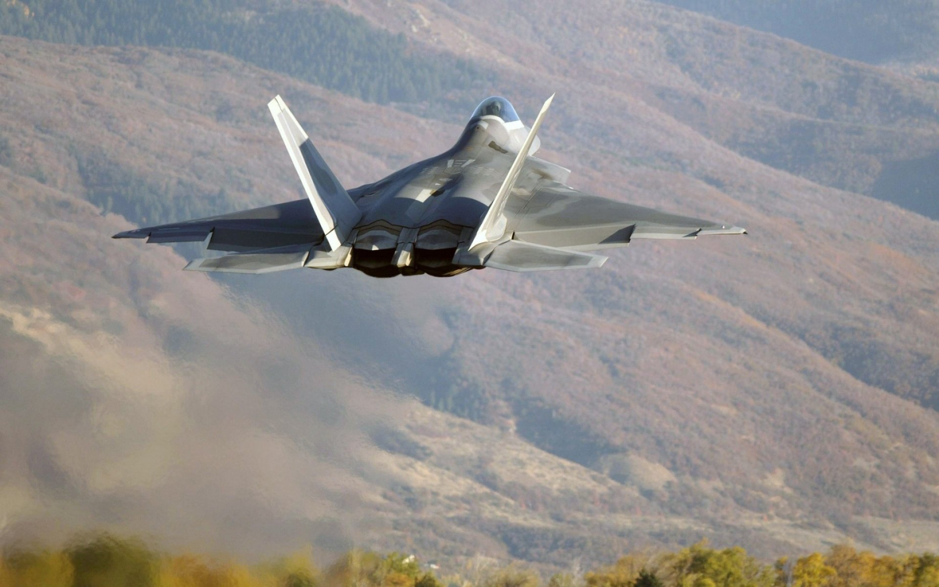 lockheed / boeing f-22 raptor multipropósito luchador quinta generación vuelo árboles montañas colinas despegue foto