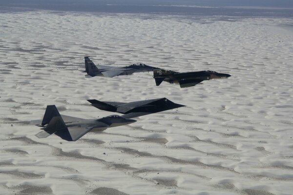 Jet da combattimento Cuneo nero opaco sopra le sabbie bianche del deserto