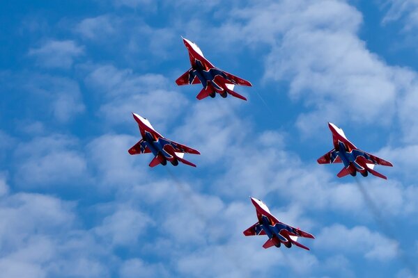 Aerobatic group of fighters in the cloudy sky