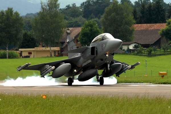 A Swedish fighter jet is taking off along the runway