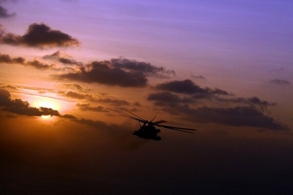 Schöner Sonnenuntergang und Helikopter Silhouette