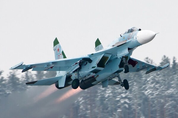 Décollage d un chasseur su-27 sur fond d arbres