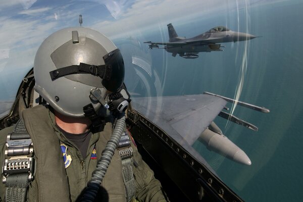 Ein Militärpilot beobachtet vom Cockpit aus ein Flugzeug, das in der Nähe fliegt