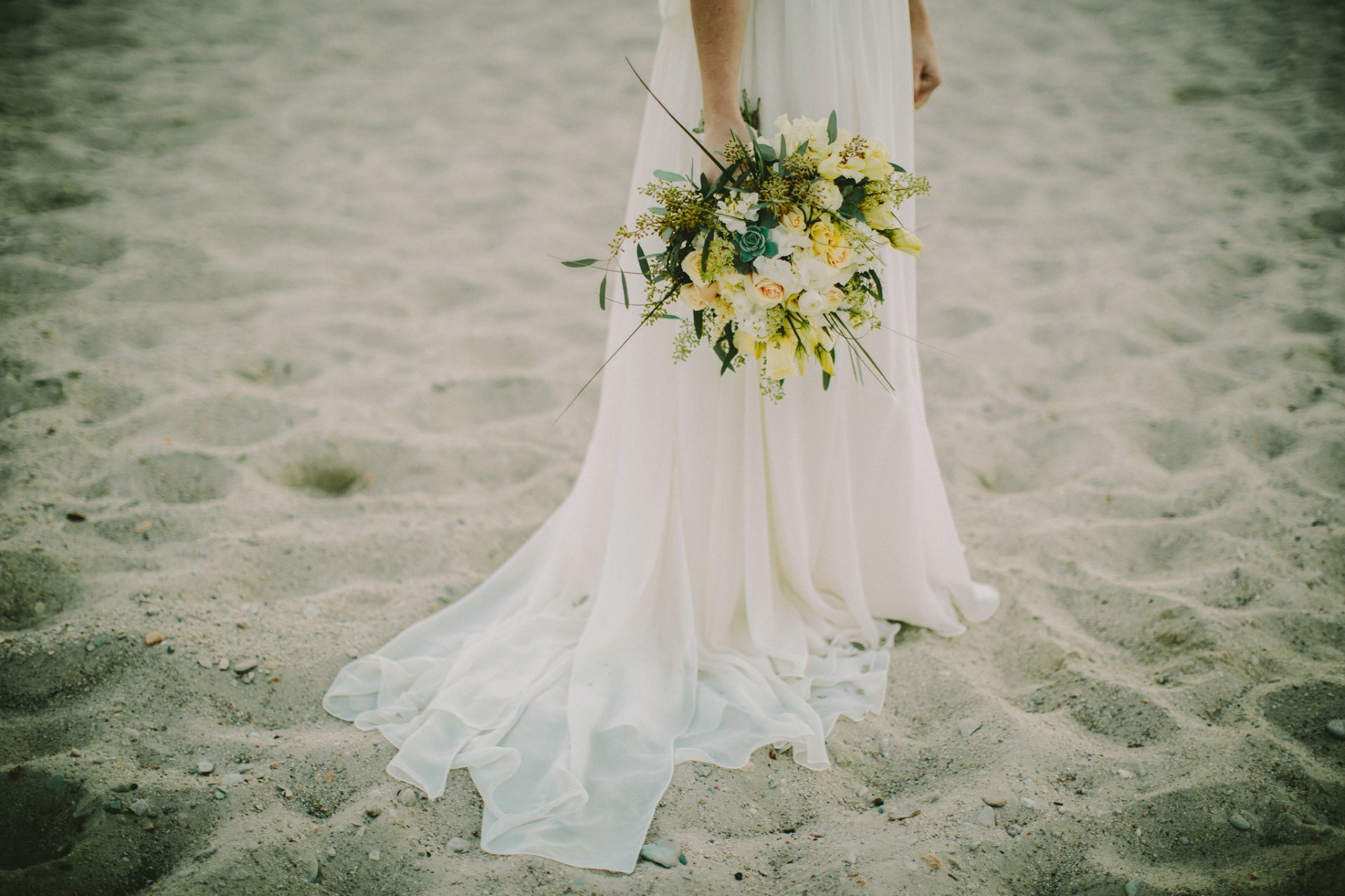 vestito sposa bianco spiaggia sabbia mazzo fiori