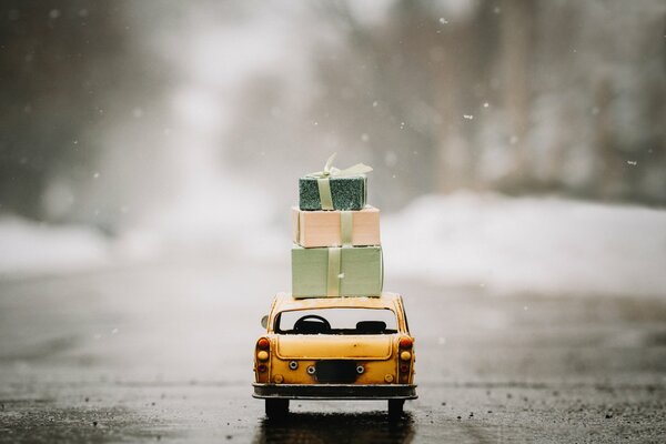 A yellow car is taking three boxes to the roofs