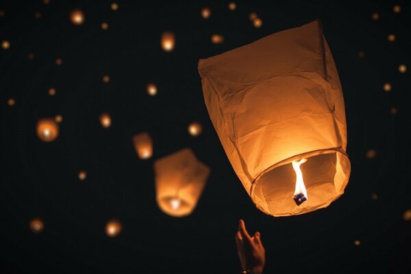 Bright glowing lanterns in the night sky