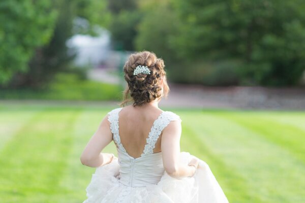 A girl in a wedding dress on the lawn