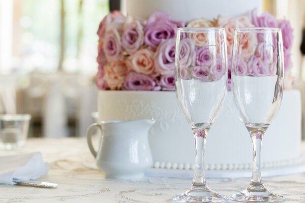 Hochzeitstorte mit Rosen und zwei Gläsern