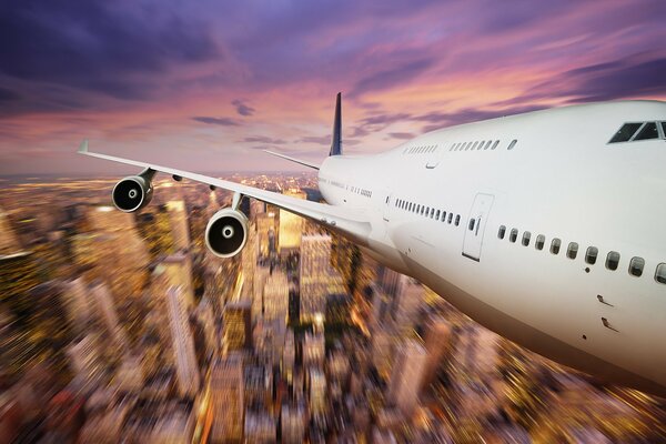 Flug eines Flugzeugs bei Sonnenuntergang über der Stadt